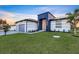 Modern home highlighting architectural design, fresh lawn, three car garage, and accent lighting at 9493 St Paul Dr, Port Charlotte, FL 33981