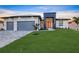 Modern home exterior with a three-car garage, contemporary design, and lush green lawn at 9493 St Paul Dr, Port Charlotte, FL 33981