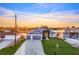 Exterior shot of a modern home featuring a three-car garage and well-manicured lawn at 9493 St Paul Dr, Port Charlotte, FL 33981