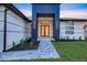 Modern home showcasing a striking blue entryway with double doors and neatly landscaped front yard at 9493 St Paul Dr, Port Charlotte, FL 33981