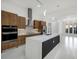 Sleek, modern kitchen with wood cabinets, a large center island, and stainless-steel appliances at 9493 St Paul Dr, Port Charlotte, FL 33981