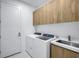 Well-organized laundry room features cabinetry, modern appliances, and a stainless sink and faucet at 9493 St Paul Dr, Port Charlotte, FL 33981
