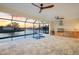 Screened-in pool area with outdoor kitchen, ceiling fans, and a view of the canal during sunset at 9493 St Paul Dr, Port Charlotte, FL 33981