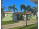 Inviting single-story home showcasing a green exterior, clay tile roof, manicured lawn, and a two-car garage at 1315 Santiago Ct, Punta Gorda, FL 33950