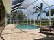 Sparkling screened pool area with ample seating, lounge chairs, and lush backyard view at 1315 Santiago Ct, Punta Gorda, FL 33950