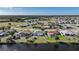 Overhead shot showcasing homes with screened-in pools near a serene waterway and a distant lake at 13632 Clara Ln, Port Charlotte, FL 33981