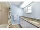 Bright bathroom featuring a double vanity with granite countertop and neutral ceramic tile floor at 13632 Clara Ln, Port Charlotte, FL 33981