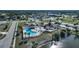 Aerial view showcasing the community pool, clubhouse, and tranquil lake, perfect for relaxation and recreation at 13632 Clara Ln, Port Charlotte, FL 33981