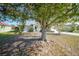 Landscaped front yard showcasing a mature tree providing shade for this charming single-story home at 13632 Clara Ln, Port Charlotte, FL 33981