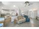 Open-concept living room with tile floors, ceiling fan, and views into the kitchen at 13632 Clara Ln, Port Charlotte, FL 33981
