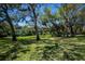 Expansive backyard features mature trees providing shade and privacy for outdoor enjoyment at 1420 Winding Oak Dr, Port Charlotte, FL 33948