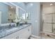 Well-lit bathroom with marble countertop, dual sinks, decorative mirrors, and glass-enclosed shower at 1420 Winding Oak Dr, Port Charlotte, FL 33948