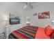 Bright bedroom with ceiling fan, dresser with television, and shuttered windows at 1420 Winding Oak Dr, Port Charlotte, FL 33948