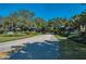 A scenic view of the community entrance surrounded by lush trees and landscaping at 1420 Winding Oak Dr, Port Charlotte, FL 33948