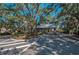A well-maintained community entrance with manicured landscaping and shaded by mature trees at 1420 Winding Oak Dr, Port Charlotte, FL 33948