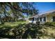 The home features a screened lanai and picturesque backyard with mature trees providing shade and privacy at 1420 Winding Oak Dr, Port Charlotte, FL 33948