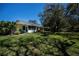Beautiful backyard with a well-maintained lawn, framed by mature trees providing plenty of shade at 1420 Winding Oak Dr, Port Charlotte, FL 33948