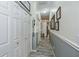Inviting hallway with wood-look flooring, paneled walls, and decorative wall art at 1420 Winding Oak Dr, Port Charlotte, FL 33948
