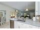 Spacious kitchen island with stainless steel dishwasher, white cabinets, pendant lighting, and an undermounted sink at 1420 Winding Oak Dr, Port Charlotte, FL 33948