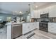 Open kitchen featuring white cabinets, gray toned counter tops, stainless appliances and seamless flow into the living area at 1420 Winding Oak Dr, Port Charlotte, FL 33948