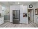 Kitchen area with white cabinets, stainless steel refrigerator, and adjacent dining area at 1420 Winding Oak Dr, Port Charlotte, FL 33948