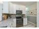 Well-lit kitchen with white cabinetry, stainless steel appliances, decorative backsplash, and gray-toned countertops at 1420 Winding Oak Dr, Port Charlotte, FL 33948