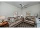 Bright living room featuring two leather sofas, ceiling fan, and neutral patterned rug at 1420 Winding Oak Dr, Port Charlotte, FL 33948