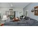 Comfortable living room featuring a large gray sectional sofa, ceiling fan, and access to the lanai at 1420 Winding Oak Dr, Port Charlotte, FL 33948