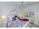 Bright main bedroom featuring a bed with floral bedding and throw pillows, side tables, and a ceiling fan at 1420 Winding Oak Dr, Port Charlotte, FL 33948