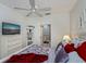 Spacious main bedroom with a ceiling fan, a television, and access to an ensuite bathroom at 1420 Winding Oak Dr, Port Charlotte, FL 33948