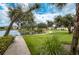 Scenic pond view with mature trees and walking path near the building at 1420 Winding Oak Dr, Port Charlotte, FL 33948