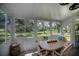 Bright sunroom with multiple windows overlooking the green landscaped backyard at 1420 Winding Oak Dr, Port Charlotte, FL 33948