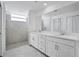Bright bathroom features double sinks, white cabinets, tile floors, tiled shower, and a large mirror at 14234 Heritage Landing Blvd # 1016, Punta Gorda, FL 33955