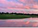 Picturesque golf course view at sunset, with beautiful pink clouds reflected in the water at 14234 Heritage Landing Blvd # 1016, Punta Gorda, FL 33955