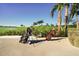 Picturesque golf course view with a clear blue sky, golf bags, palm trees, and serene water feature at 14234 Heritage Landing Blvd # 1016, Punta Gorda, FL 33955
