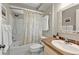 Cozy bathroom featuring a tub-shower, patterned shower curtain and a single sink vanity with a decorative mirror at 155 Francis Ne Dr, Port Charlotte, FL 33952