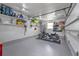 Spacious garage with epoxy flooring, storage shelves, and a motorcycle parked on a mat at 155 Francis Ne Dr, Port Charlotte, FL 33952