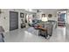 Open-concept living area with gray sectional, tiled floors, and adjacent bedroom at 155 Francis Ne Dr, Port Charlotte, FL 33952