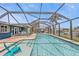 Inviting screened-in pool area with lounge seating and dining space, perfect for entertaining and relaxation at 155 Francis Ne Dr, Port Charlotte, FL 33952