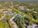 Overhead view of a bright blue house with a pool, a privacy fence, and mature landscaping at 1563 Arundel Ave, North Port, FL 34288