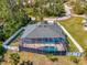 An aerial view of a lovely house with a screened pool and fenced yard, surrounded by trees at 1563 Arundel Ave, North Port, FL 34288