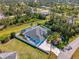 An aerial view showcases the pool, fenced yard, and verdant surroundings at 1563 Arundel Ave, North Port, FL 34288