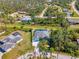 An aerial view of a house with a pool, beautiful landscaping and lots of surrounding trees at 1563 Arundel Ave, North Port, FL 34288