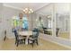 Cozy dining room with a round table, chandelier lighting, and large mirrors reflecting natural light at 1563 Arundel Ave, North Port, FL 34288