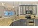 A bright kitchen features gray cabinets, granite countertops and stainless steel appliances at 1563 Arundel Ave, North Port, FL 34288