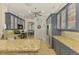 Well-lit kitchen with stainless steel appliances, stylish cabinetry, granite countertops, and neutral tile flooring at 1563 Arundel Ave, North Port, FL 34288