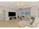 Cozy living room featuring neutral tile flooring, a comfortable sofa, a large window, and a ceiling fan at 1563 Arundel Ave, North Port, FL 34288