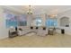 Open-concept living area with tile floors, plenty of seating, and bright windows at 1563 Arundel Ave, North Port, FL 34288