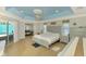 A main bedroom with a light-blue ceiling, an exit to the patio, and a glimpse into the lounge area at 1563 Arundel Ave, North Port, FL 34288
