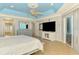 Spacious main bedroom featuring a tray ceiling, large TV, and access to outdoor patio at 1563 Arundel Ave, North Port, FL 34288